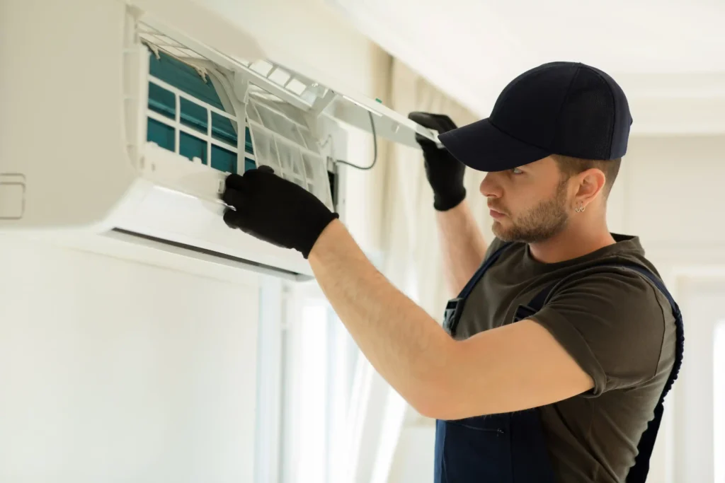 Technician lifting front panel of air conditioner for maintenance or repair